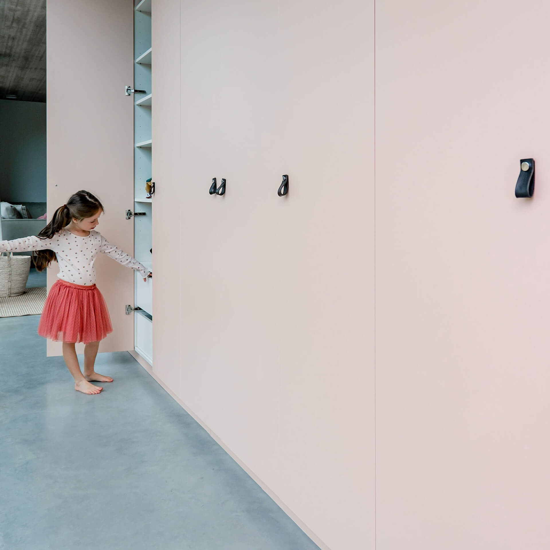 a girl opening the closet door of the bespoke cabinet in Tanned Peach from maatkastenonline