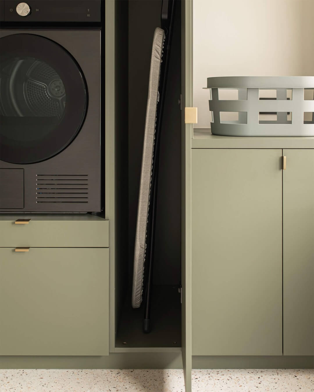 Space for an ironing board in the bespoke laundry cupboard