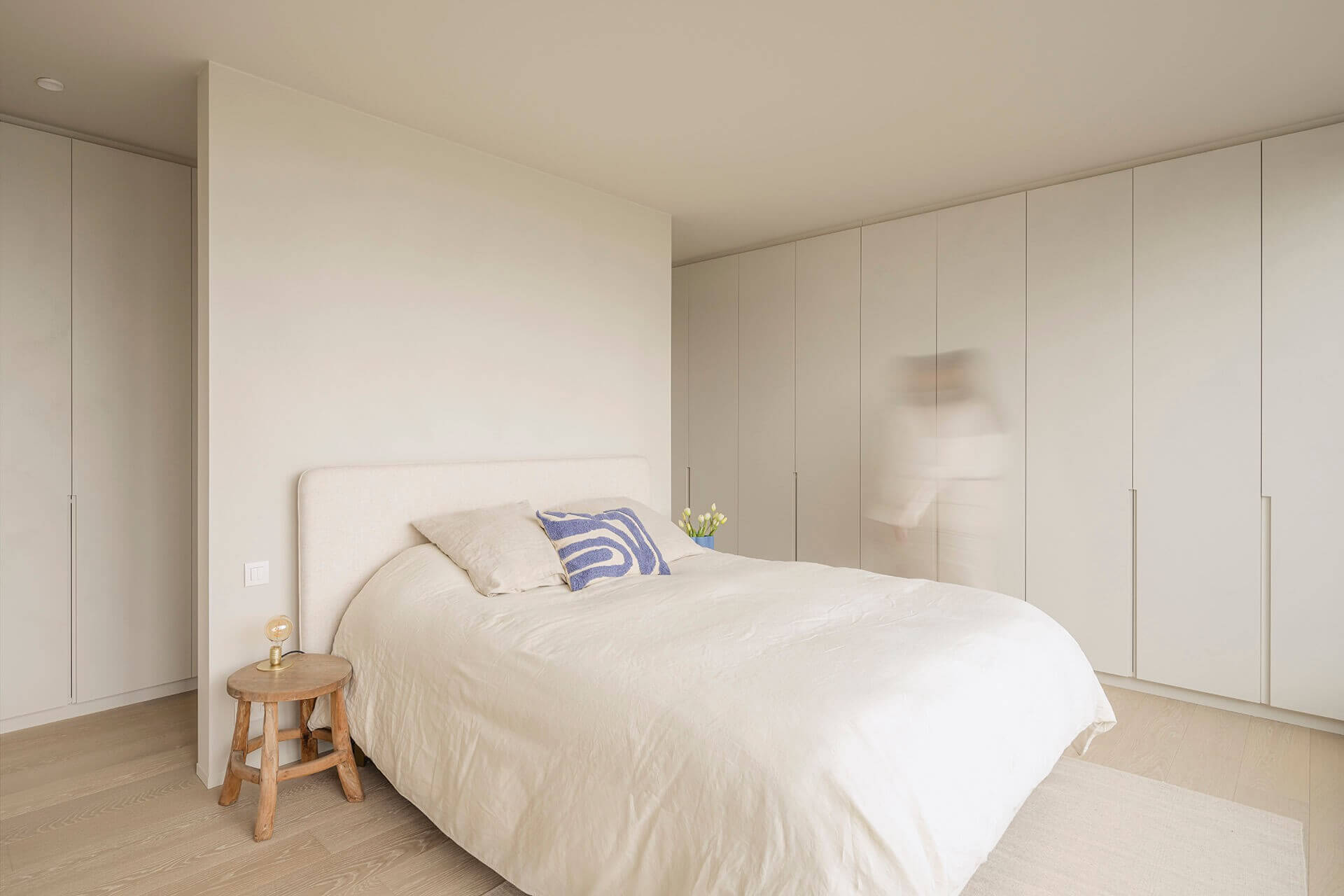 Armoire à vêtements dans une chambre à coucher de caractère minimaliste revêtue d'une peinture texturée 