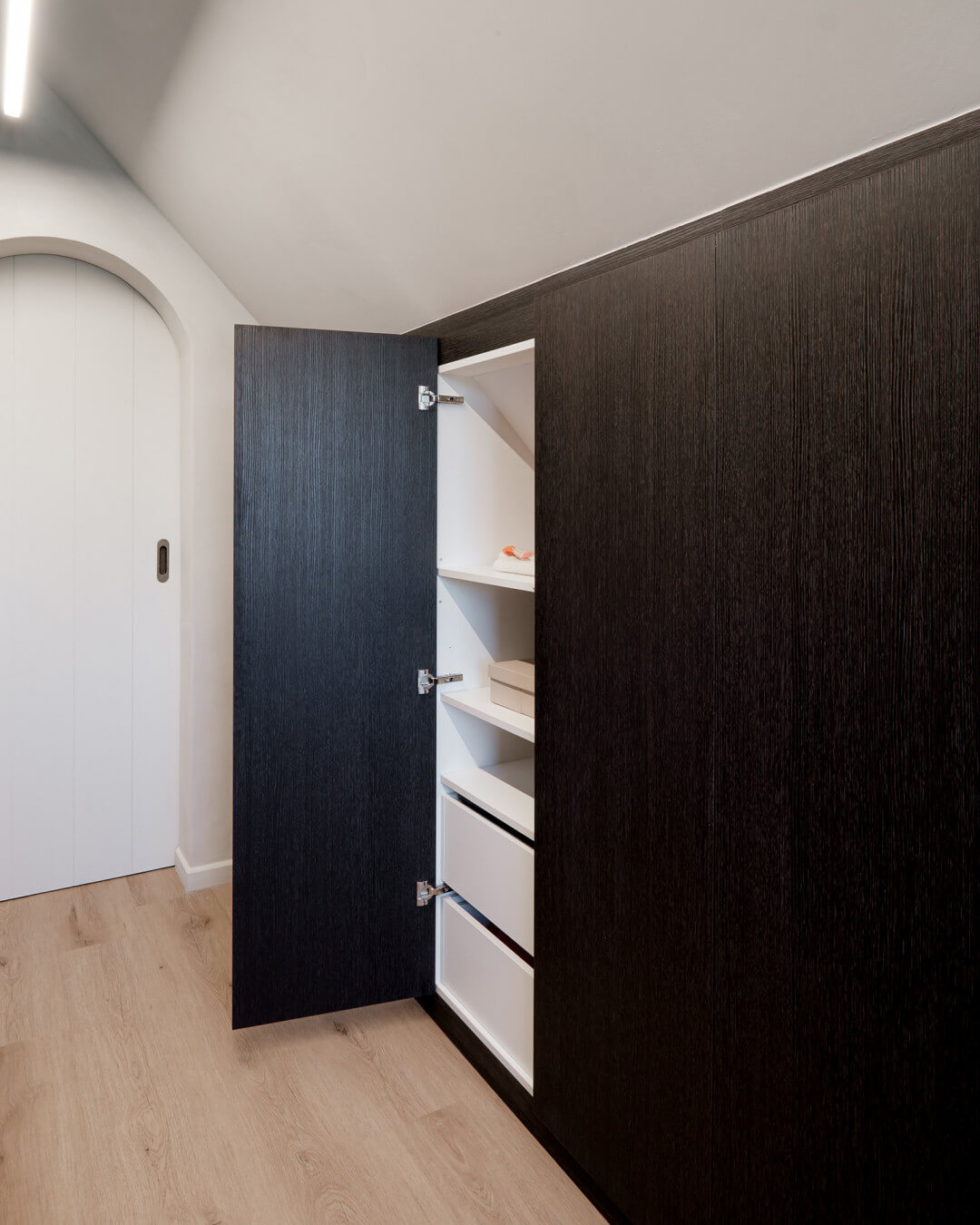 Kledingkast met schuine rug onder een hellend dak 