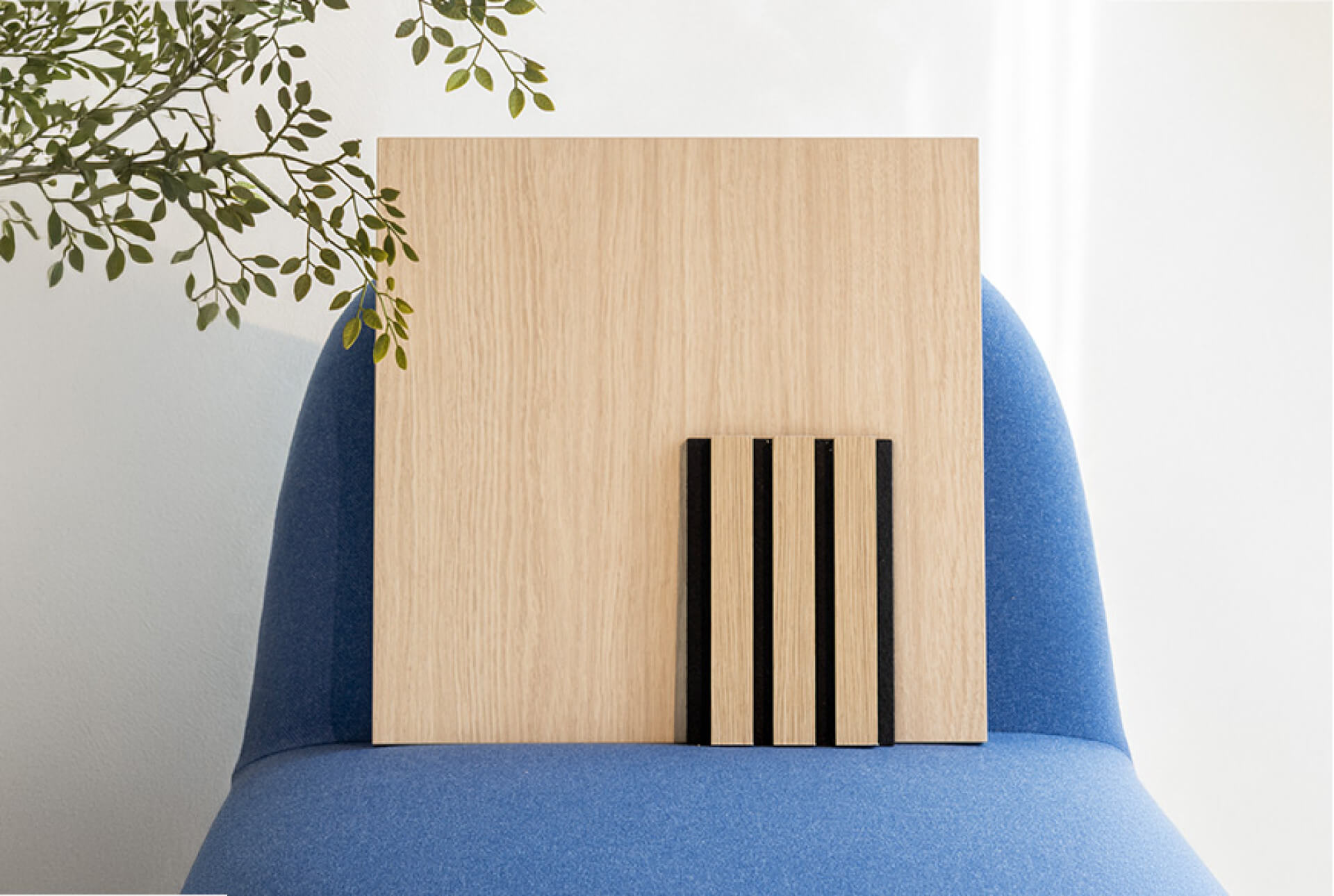 Staal van een Ivory Oak akoestisch wandpaneel op een blauwe stoel