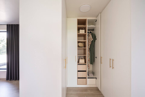 Een hoekkast in u-vorm in Front White met diamond messing handgrepen in een slaapkamer