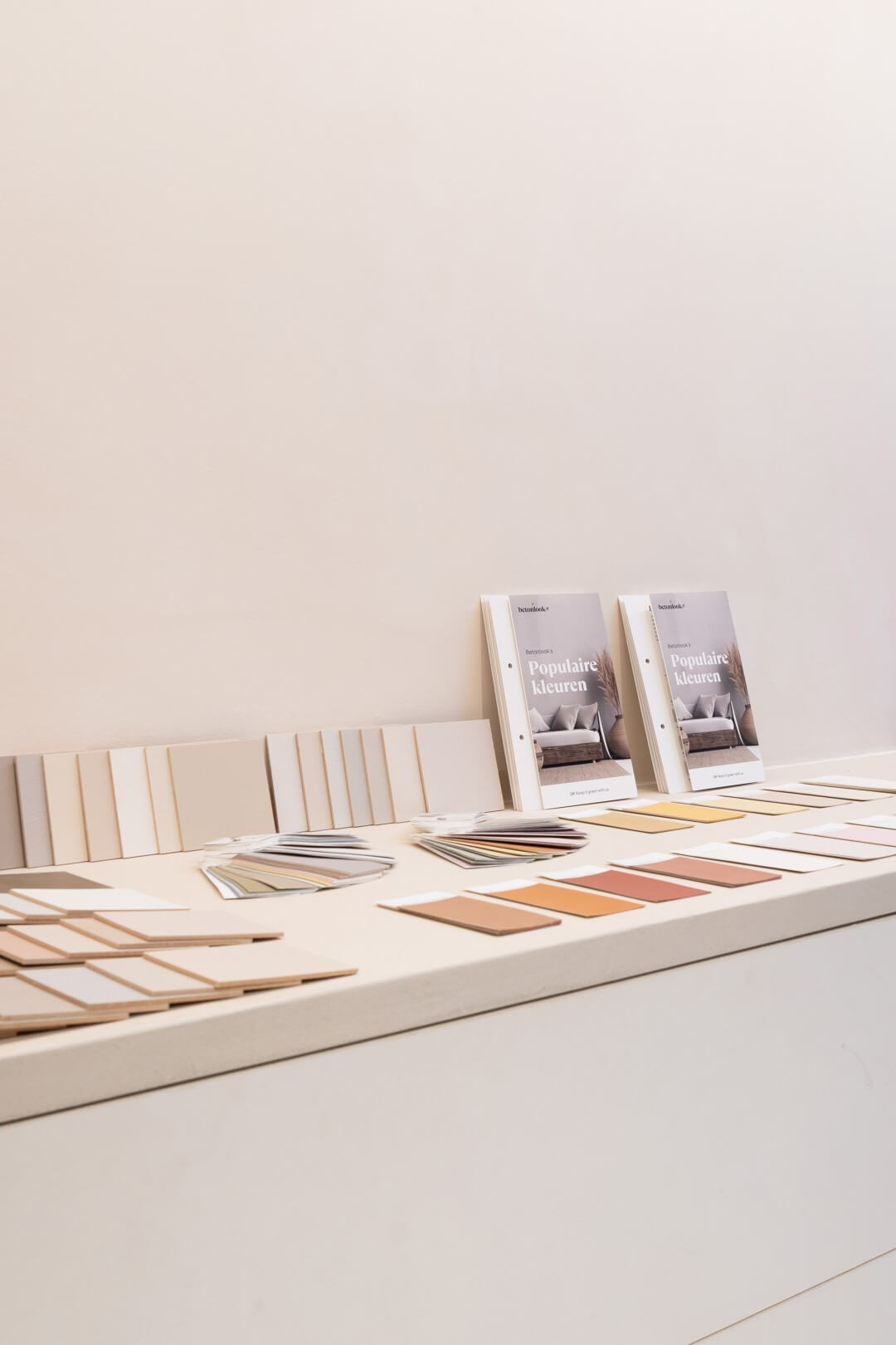Overzichtsfoto van folder van Betonlook samen met kleurstaaltjes verf