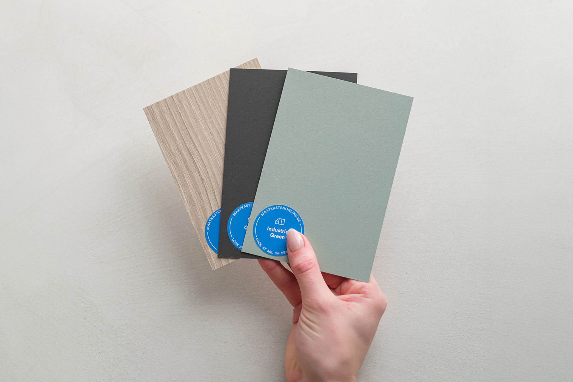 Hand met gratis kleurstalen voor je maatkast 