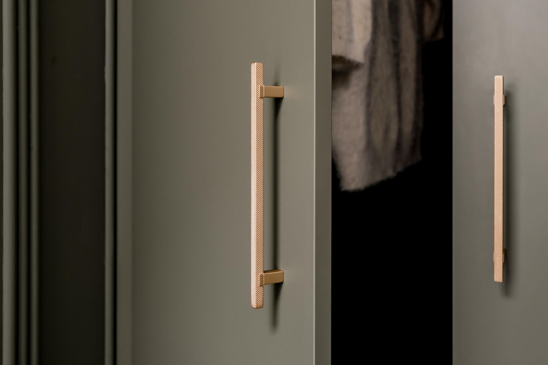 Messing handgrepen op een groene maatkast van Maatkasten Online