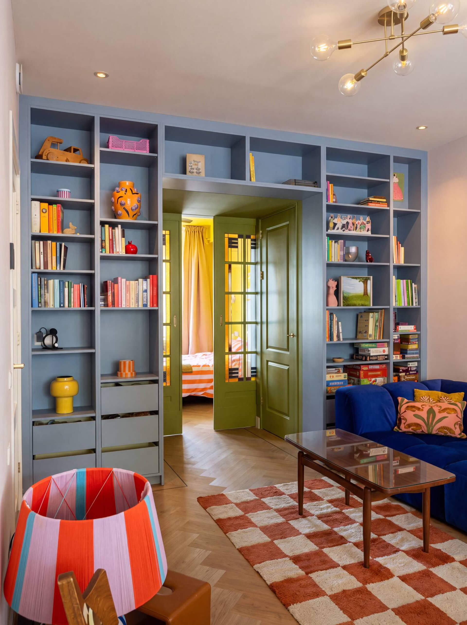 Boekenkast tot aan het plafond rond een deur in een blauwe kleur