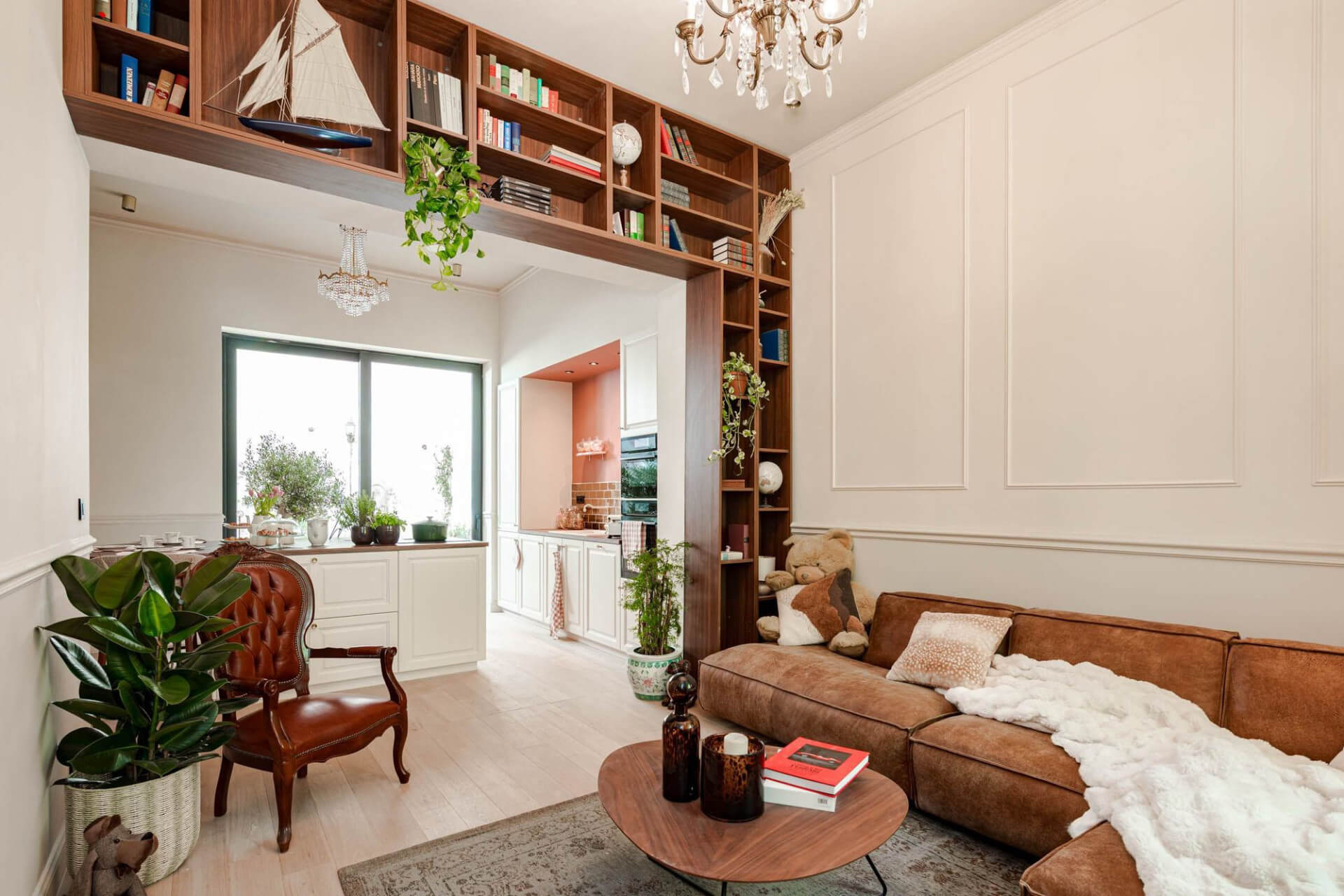 Boekenwand op maat in walnut rond een doorgang tussen woonkamer en keuken