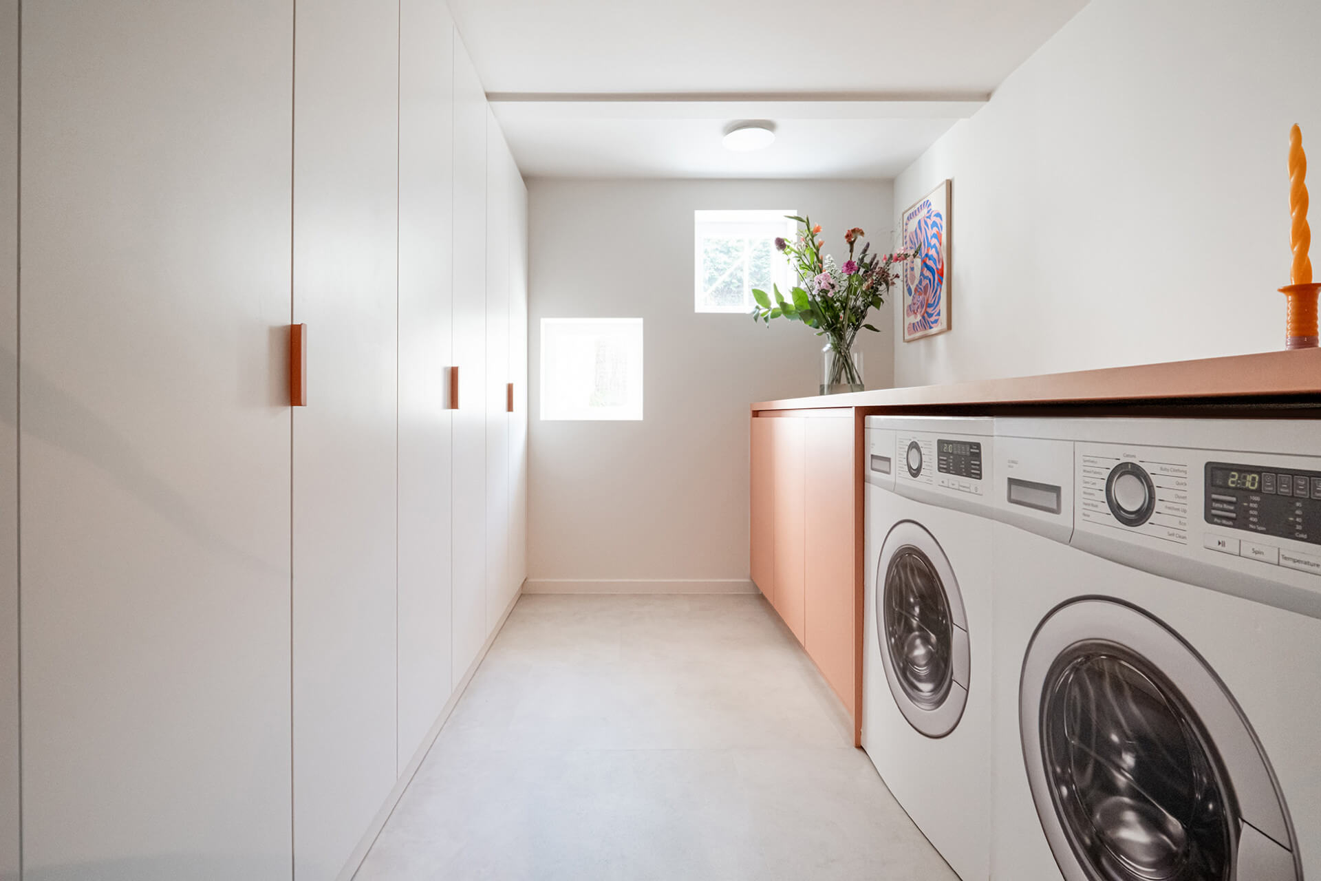 Custom white storage cabinet in a laundry room from Maatkasten Online.