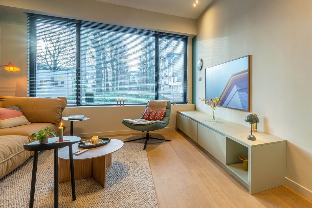 Woonkamer met op maat gemaakt tv meubel in een zachte grijs-groene kleur