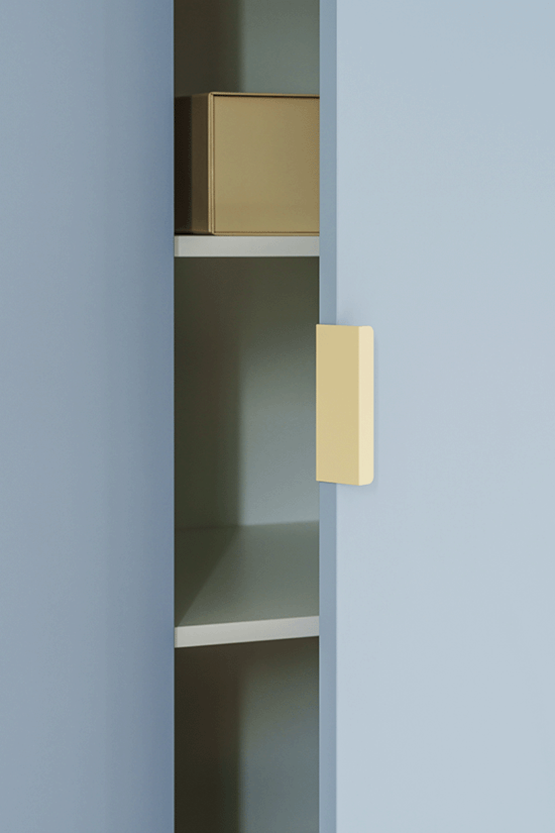 Detail shot van de Tonton creme handgrepen die werden gemonteerd op een Silver Blue op maat gemaakte kledingkast. De deur van de kast staat half-open.