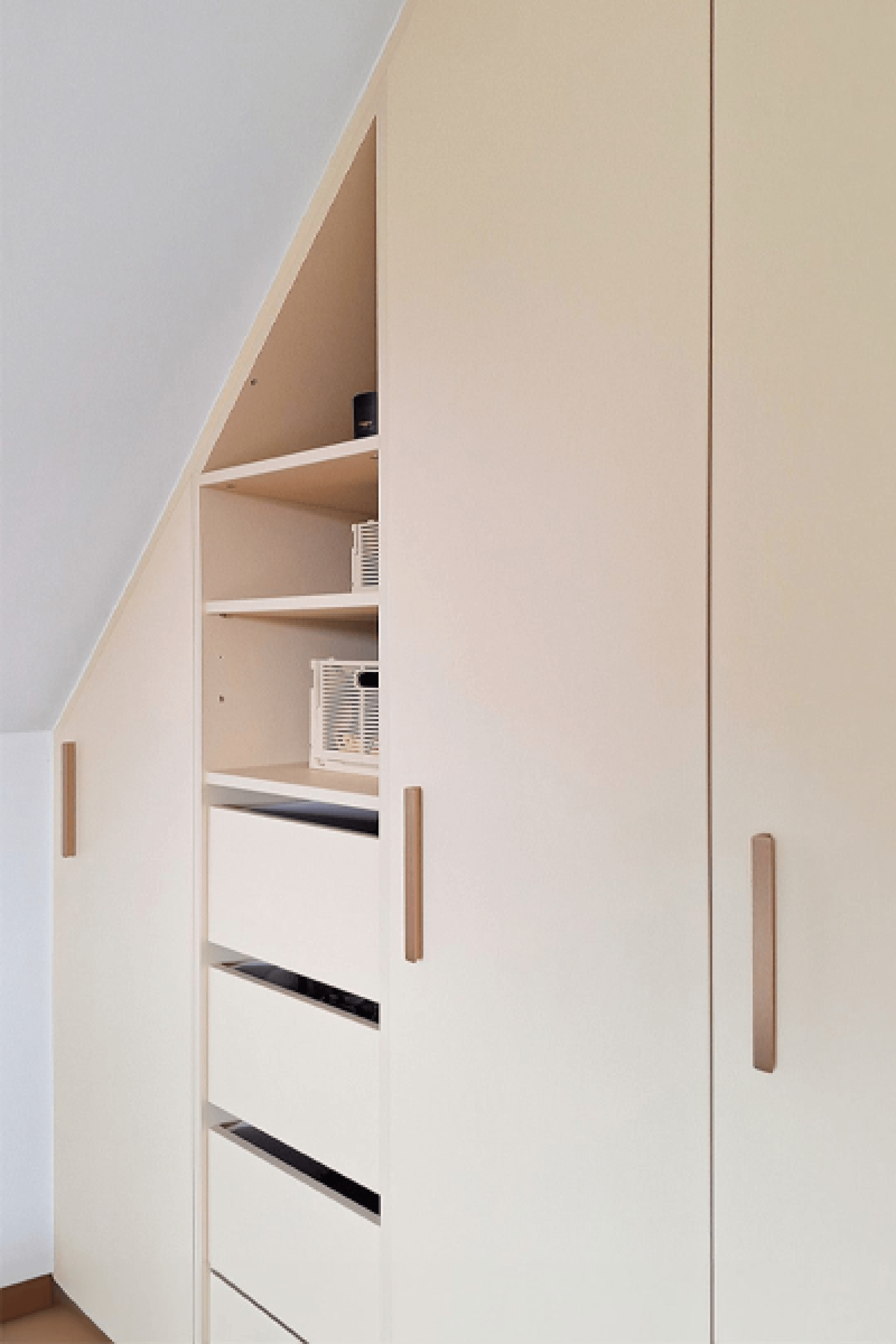 Detail shot of white custom-made slanted dressing cabinet with brass bar handles