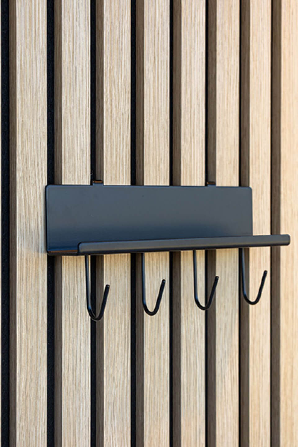 Linker zijaanzicht van een wandplank met haakjes op akoestische wandpanelen. Verkrijgbaar in de Maatkasten Online boetiek.