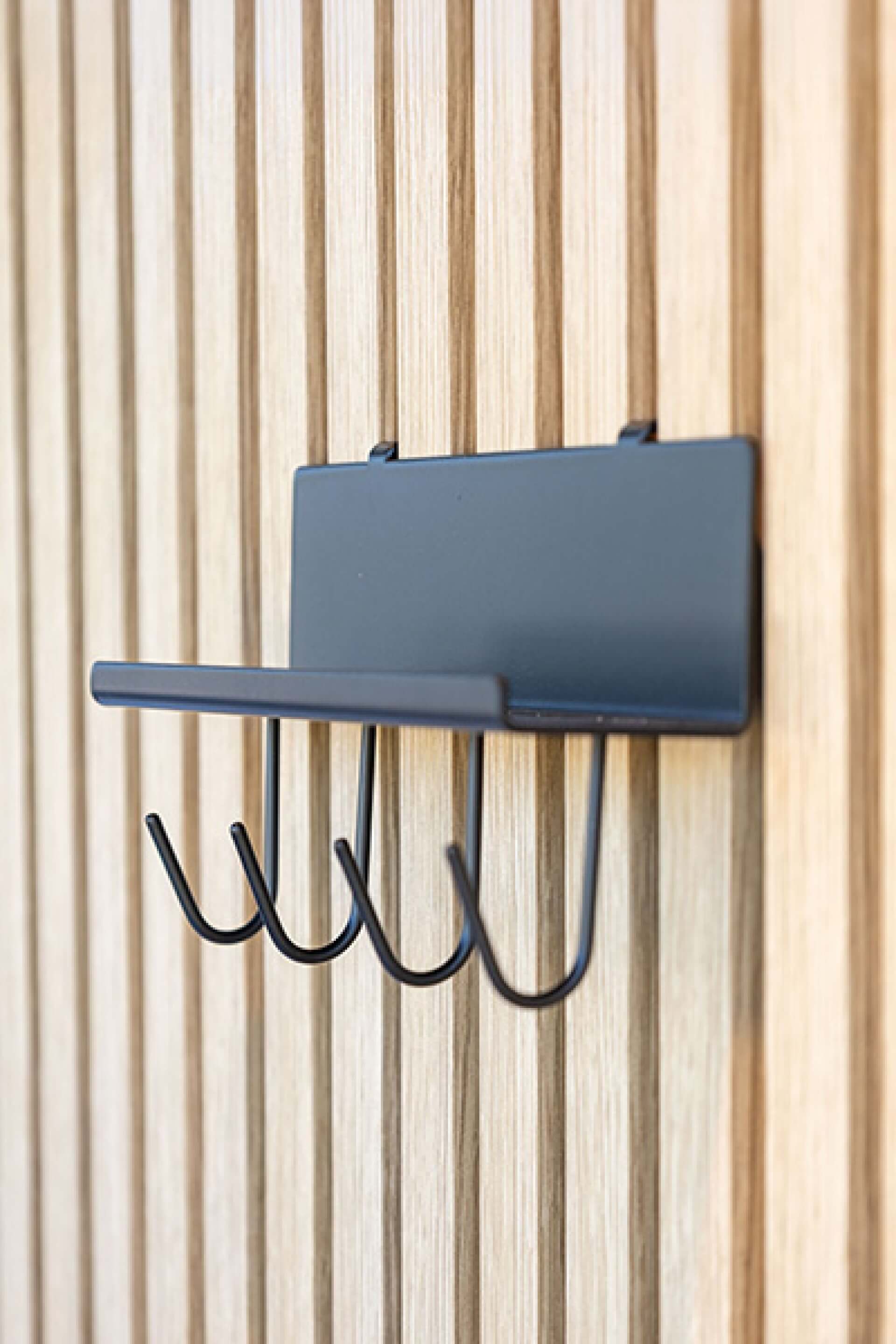 Rechter zijaanzicht van een wandplank met haakjes op akoestische wandpanelen. Verkrijgbaar in de Maatkasten Online boetiek.