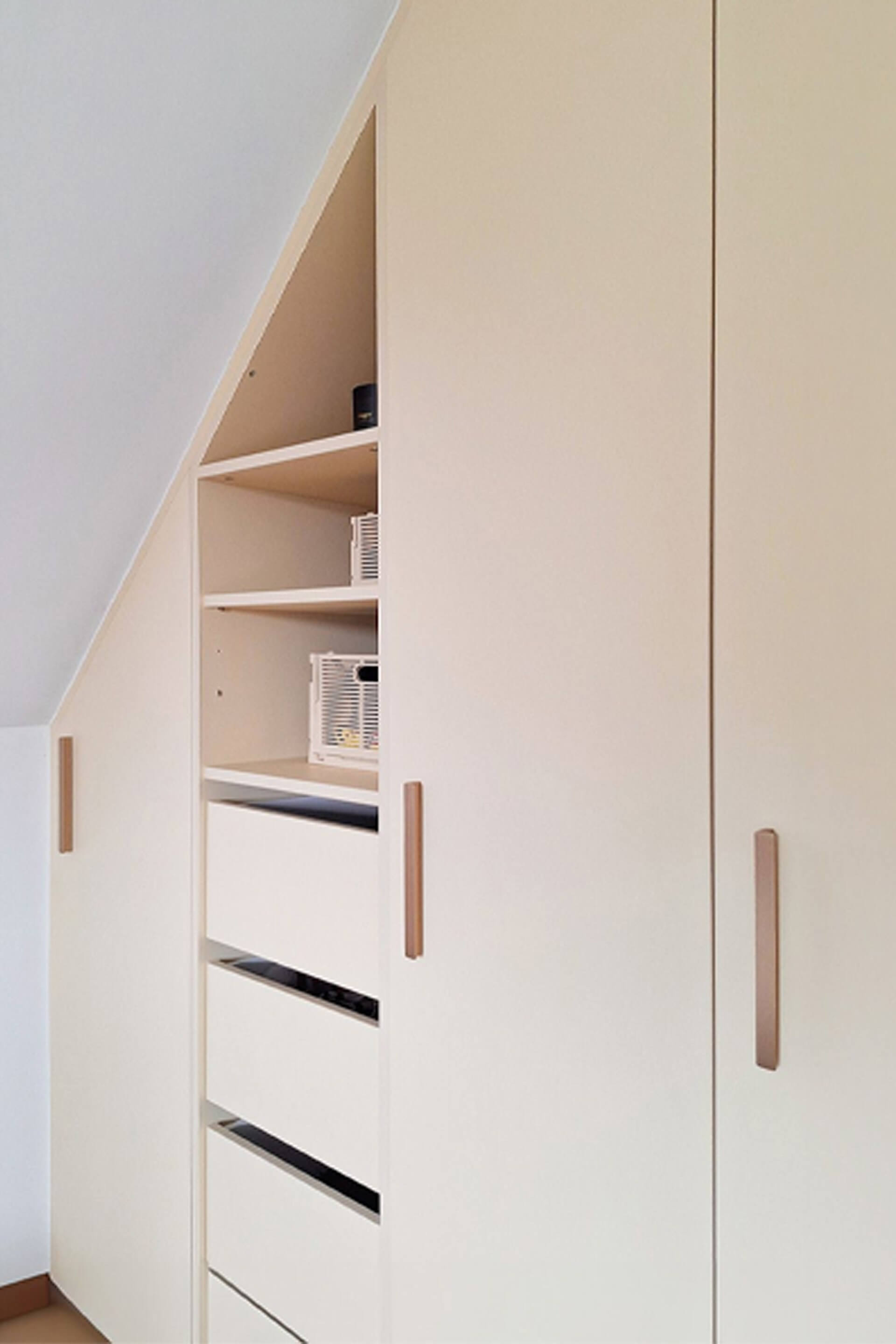 Detailshot van witte op maat gemaakte schuine dressingkast met Bar handgrepen in messing