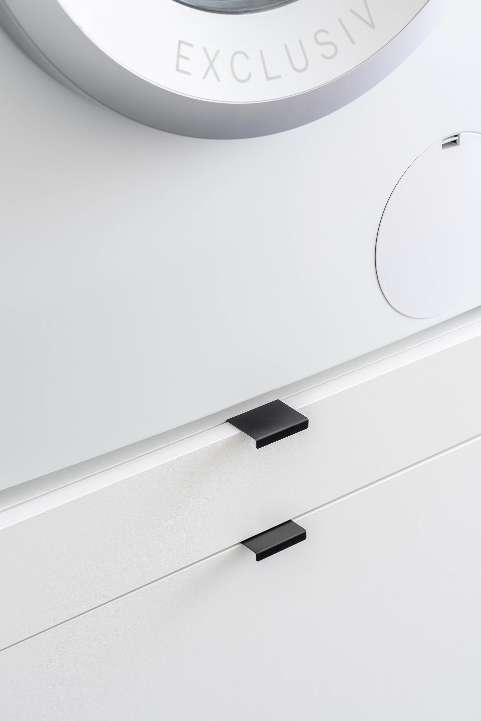 Detail shot of a custom-made Front White laundry cabinet onto which black Mini Pure handles were mounted.