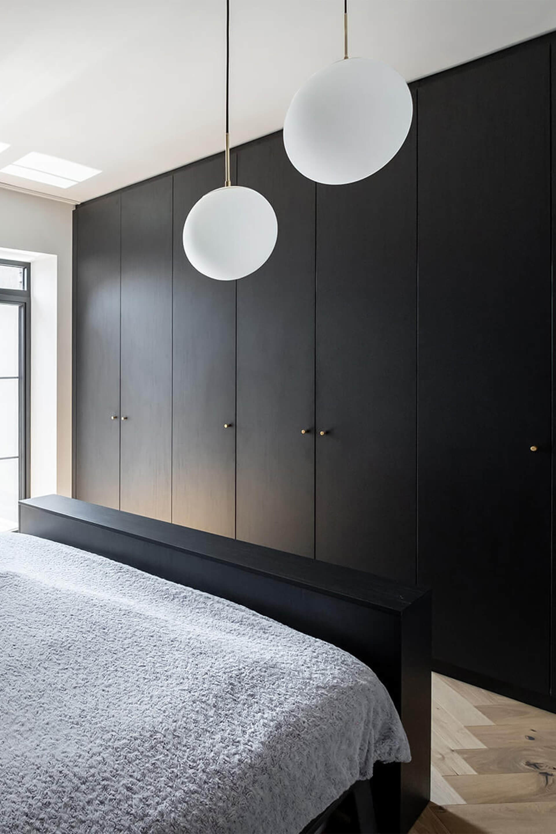 Slaapkamer met op maat gemaakte kleerkast in Elegant Black met Monument handgrepen in messing.