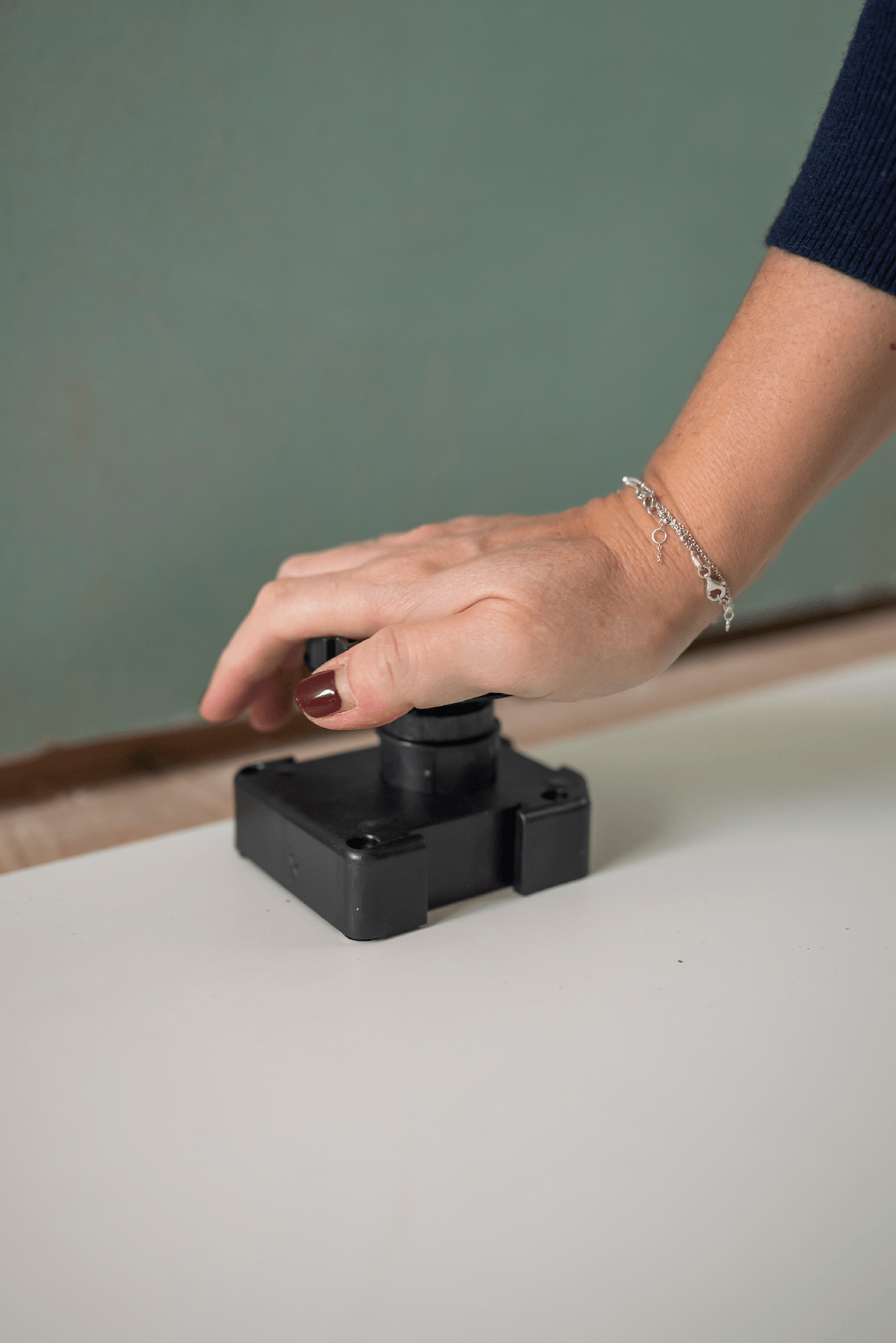 Sokkelpoot van 60 mm geduwt op het onderstel voor sokkelpoot. Deze stevige kunststof poten worden gebruikt als onderstel voor maatkasten, zorgen voor een stabiele plaatsing en zijn eenvoudig verstelbaar. De close-up toont zowel de bovenkant als het tandwielsysteem dat voor een nauwkeurige afstelling zorgt.